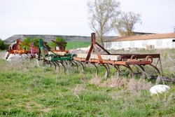 Photograph of used and old agricultural machinery, four old plows that are abandoned in an agricultural and livestock plot, the plows are in disuse and rusting. Decline of agriculture. Selective focus