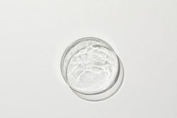 Petri dish with water and ripple in cream-colored background 