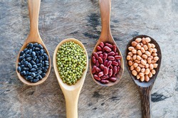 Natural grains consisted of black beans, green beans, red beans, and peanuts in wooden spoon on wooden background