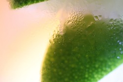 Clear frosty glass with cut lime and icy drinks. Close up macro image photograph.