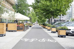 City street with long bicycle lane near outdoor cafe