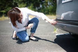 Woman checking for car scratches