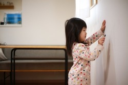 Girl scribbling on the wall 
