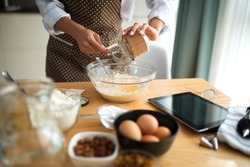 Young woman in the kitchen and inserts ingredients