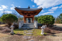 A wide angle photo of a traditional Korean pavillion in the Bell Garden of the Meadowlark Botanical Gardens in Vienna, Virginia.