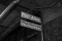 Black and white Post Alley and Pike Place Market directional signs at the gum wall in Seattle, Washington, USA 