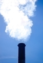 White smoke from the boiler room chimney against the blue sky.