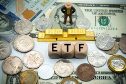 exchange-traded fund (ETF) is a type of pooled investment security that operates much like a mutual fund.The word is written on money and gold background