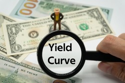Yield Curve.Magnifying glass showing the words.Background of banknotes and coins.basic concepts of finance.Business theme.Financial terms.