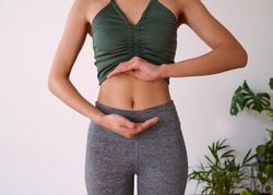 Cropped shot of a young multi-ethnic woman's stomach cupped by her hands