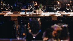 tableware Glasses, flower fork, knife served for dinner in restaurant with cozy interior