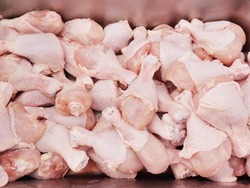 Raw chicken drumsticks are placed in a stainless steel compartment. sold in supermarkets