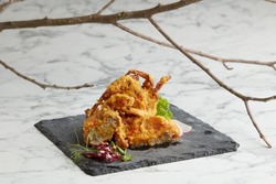 Crispy Soft Shell Crab tossed with Salted Egg Yolk served in a dish isolated on grey background