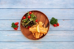Valle Battered Cod Fish And Chips with salad, lime and cherry tomato Served in dish isolated on wooden table top view fastfood