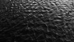 black sea water texture. water reflection texture background. Dark background, High resolution background of dark water or oil surface. Ocean surface dark nature background. River lake rippling Water.