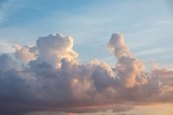 Sunset on blue sky. Blue sky with some clouds. blue sky clouds, summer skies, cloudy blue sky background. Aerial sunset view.  Evening skies with dramatic clouds. View over the clouds.