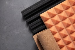 Acoustic foam and cork board at concrete wall background texture. Sound isolation material for record studio or house renovation