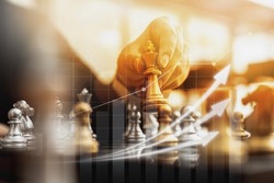 Person holding golden chess pieces to run a game, conceptual image of businessman playing chessboard compared to managing a business on risk, chart graphics showing financial flows.