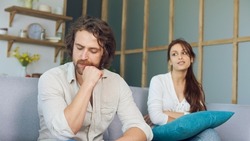 Couple Quarreling Sitting on the Couch at Home, Boyfriend Screams Accusing Girlfriend. Relationship Problems by Reason of Disagreement. The Man and Woman are Arguing. Young Woman Feeling Lonely.