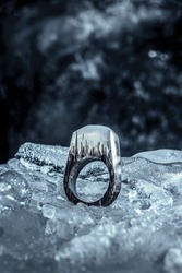 Wooden jewlery which is ring with resin top on the backghround made with ice