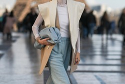Street style outfit – Woman wearing an oversized vest and a pastel blue leather clutch bag – StreetStyleFW2020