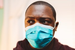 african american man in blue and white surgical  face mask