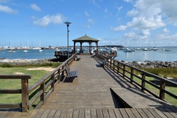 Photography of a wooden pier and a gazebo and the boats anchored at  the port of Punta del Este City, Uruguay 
