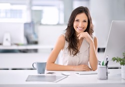 She's made it. Shot of an attractive businesswoman sitting at her desk in an office.