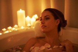 Soothed by the ambiance and a hot bath. Cropped shot of a gorgeous woman relaxing in a candle lit bath.