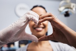 We love to see you smile just like you do. Cropped shot of a dentist and patient making a heart shaped gesture with their hands.