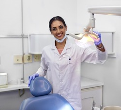 Dont forget to schedule regular checkups with your dentist. Portrait of a young female dentist standing alongside the dental chair in her office.