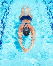 Gliding the remaining few metres. High-angle view of a female swimmer gliding through the pool.