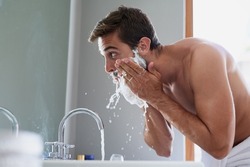 Start your day with a splash. Cropped shot of a handsome young man in his bathroom.