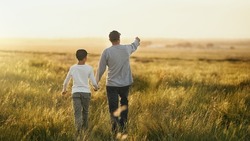 This will all be yours, son. Shot of a man taking his son for a walk out on an open field.