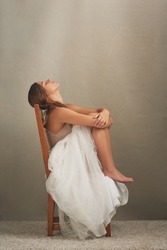 Dont believe everything you think. Studio shot of an attractive young woman looking depressed while sitting on a chair.