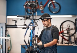 Giving your bike the attention it deserves. Shot of a man working in a bicycle repair shop.