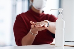 Proper hand hygiene can reduce the spread of germs. Closeup shot of an unrecognisable businesswoman using hand sanitiser in an office.