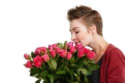 Stop and smell the roses. Studio shot of a young woman smelling a bouquet of flowers against a white background.