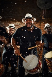 Their beats will keep you dancing all night long. Portrait of a group of musical performers playing drums together.