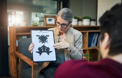 Change your perception, transform your life. Shot of a mature psychologist conducting an inkblot test with her patient during a therapeutic session.