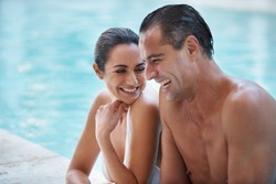 He knew how to make her laugh. Cropped shot of a loving mature couple relaxing in a pool.