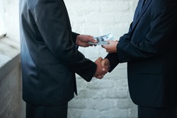 Nice doing business with you. Two corporate businessmen shaking hands and making a financial deal.