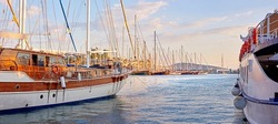 The marine harbor of Bodrum, Turkey. Scenic view of expensive yachts moored in Milta Marina. Closeup of boats and yachts docked at a port or pier during sunset on the water during a warm summer day