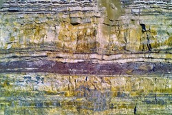 Background of textured layers of earth, sedimentary minerals and stones. Mining underground geological strata rock or sand for geology studies. Closeup of remote layered stone detail with copyspace
