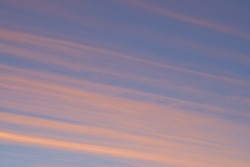 View of clouds streaked across the sky at sunset with copyspace. Soft pastel lines of colour in nature, blue sky in the late afternoon. Zen, open clear sky offering a calm, gentle reminder to breathe
