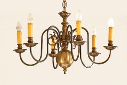 Classy vintage hanging lights for a grand foyer or dinning room. Golden candle like lighting object for a royal Victorian interior style design. Brass chandelier hanging with many light bulbs.