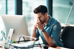 Businessman suffering from a headache or migraine due to stress caused by deadlines and work pressures. Professional in pain feeling anxious, overwhelmed and stressed while busy on his computer desk