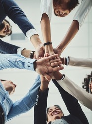 Teamwork, collaboration and unity between business people with their hands stacked for project development and innovation. Group of corporate colleagues united, joining or working together from