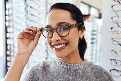 Woman wearing pair of trendy glasses, stylish spectacles and new prescription lenses at an optometrist. Portrait of a customer choosing, buying and shopping for frames for better vision and eyesight