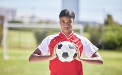 Soccer, football and sports with player, woman and athlete ready for a match, game or competition with ball on a pitch, field or stadium outdoor. Portrait of serious black female ready for training